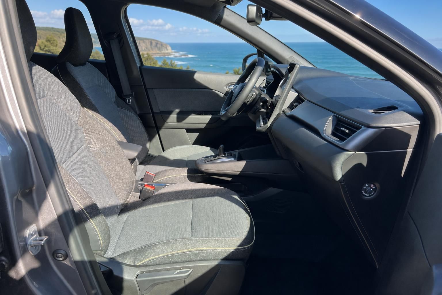 Fahrzeug Innenraum mit grauen Sitzen und Meerblick durch offene Tür