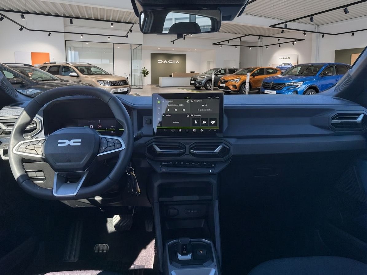 Dacia Innenraum Cockpit mit Lenkrad, Touchscreen Display und Blick auf Autohaus Ausstellung