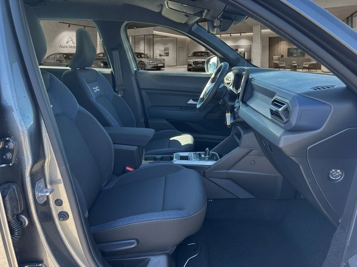 Dacia Fahrzeug Innenraum Vordersitze schwarz mit Stoffbezug und Blick in Autohaus Showroom