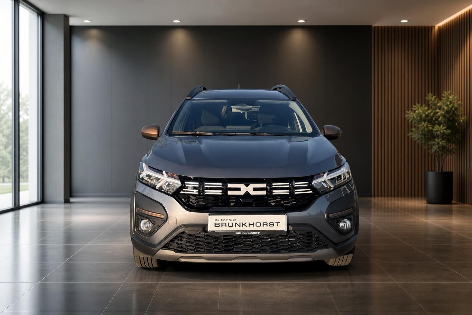 Dacia SUV Frontansicht in grau - moderner Kühlergrill und LED-Scheinwerfer im Showroom