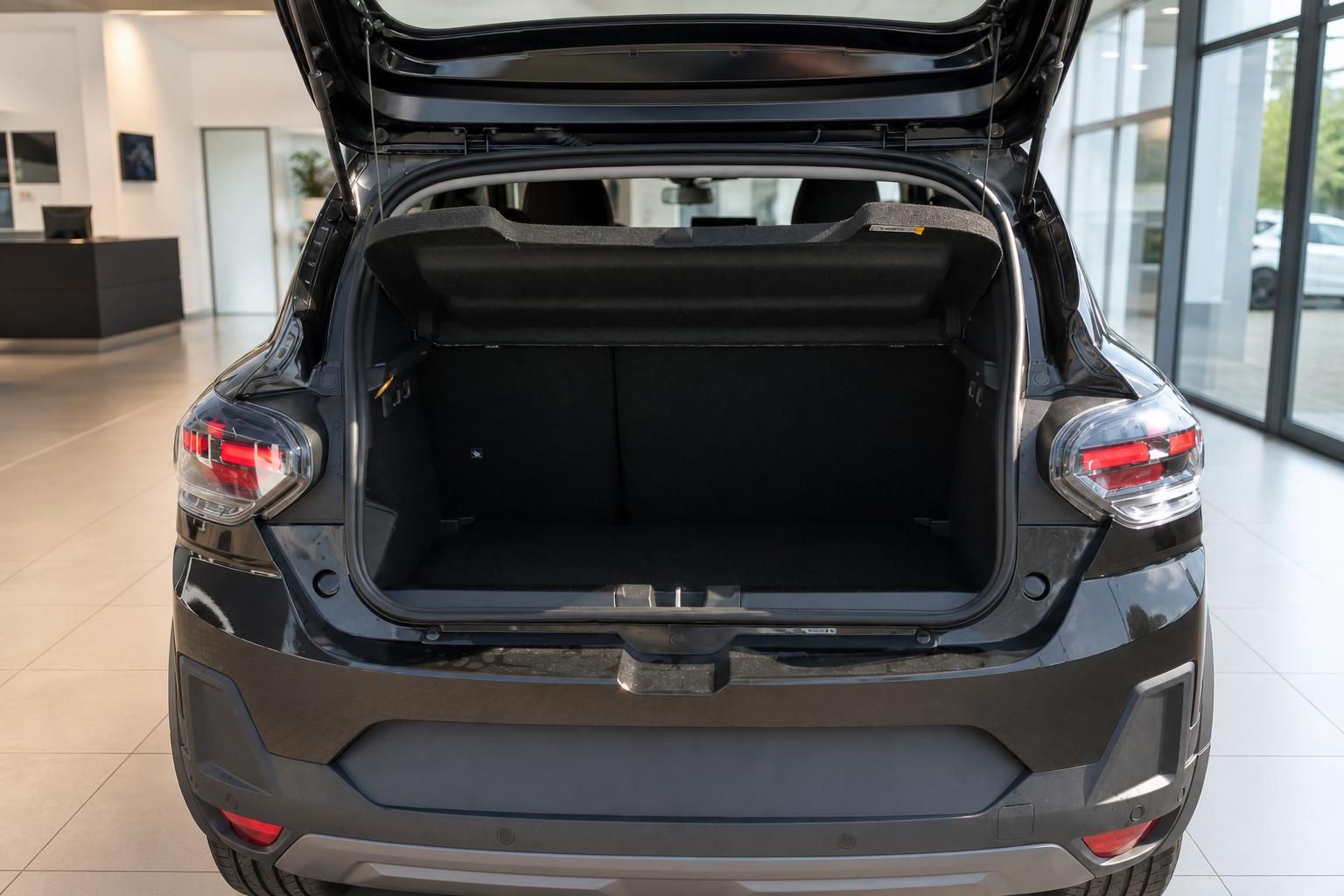 Geöffneter Kofferraum eines schwarzen SUV im Autohaus mit großem Laderaumvolumen