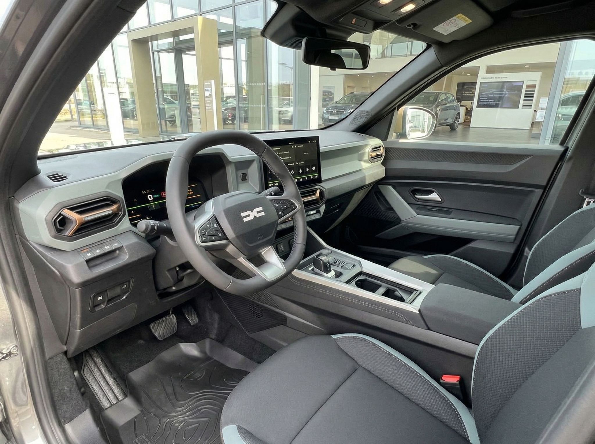 Dacia SUV Innenraum - modernes Cockpit mit Touchscreen und grauen Sportsitzen