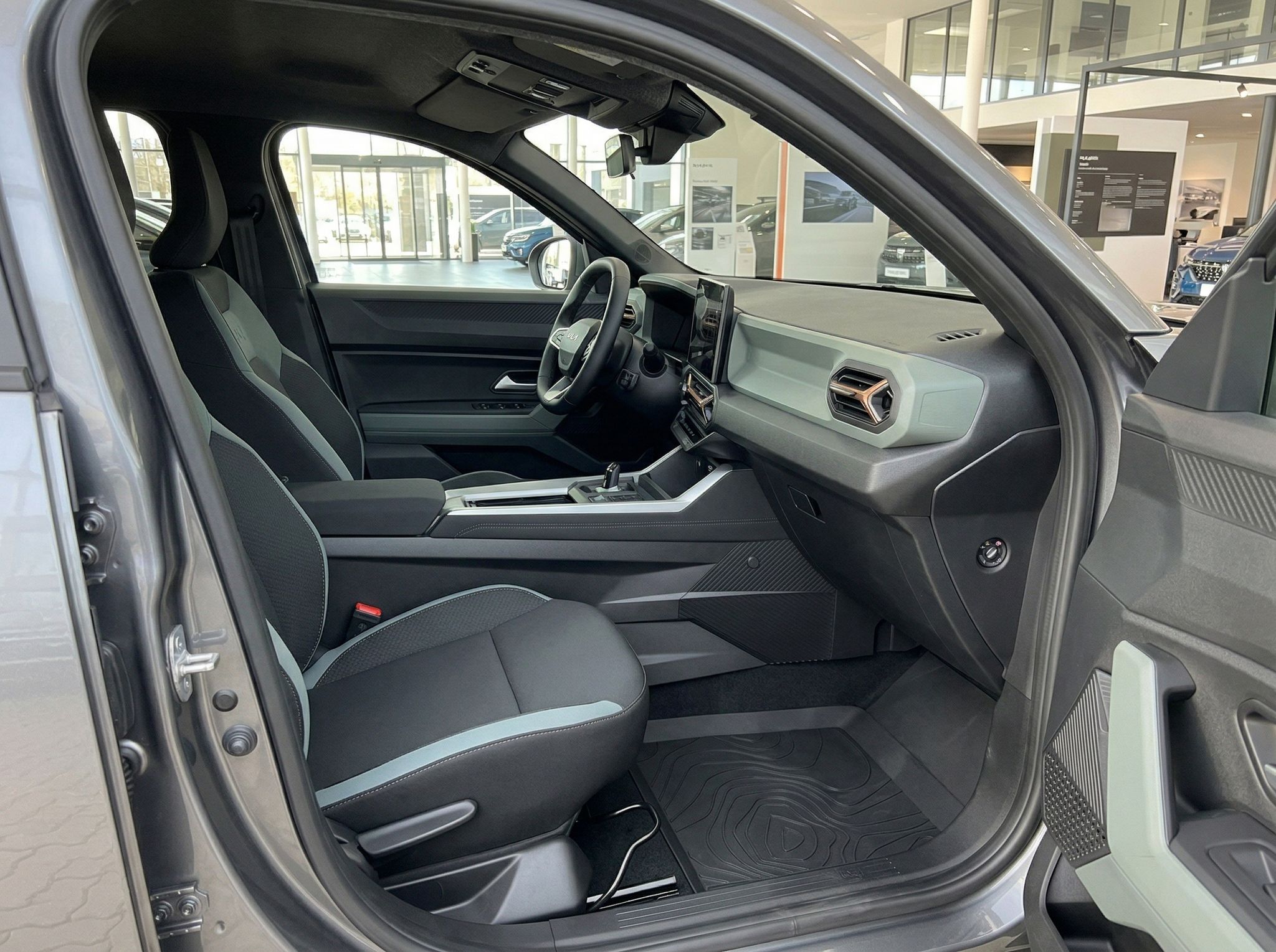 Beifahrersitz und Armaturenbrett eines modernen Fahrzeugs mit geöffneter Tür