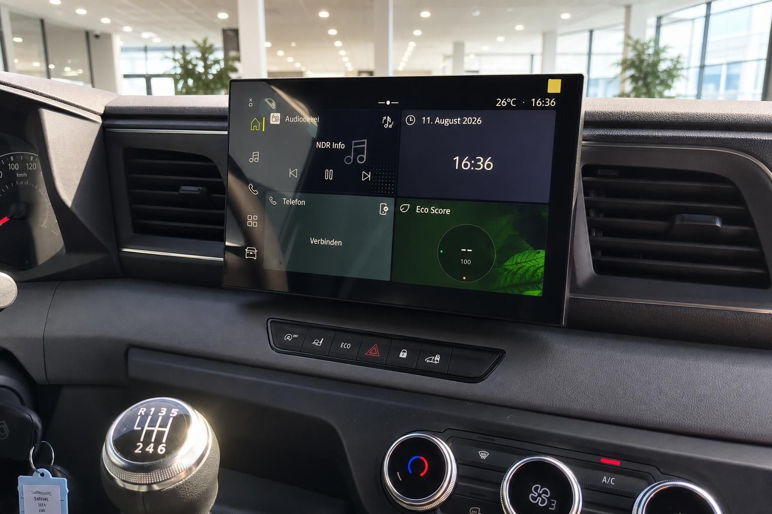 Infotainment Touchscreen mit Uhrzeit und Eco Score Anzeige im Fahrzeug