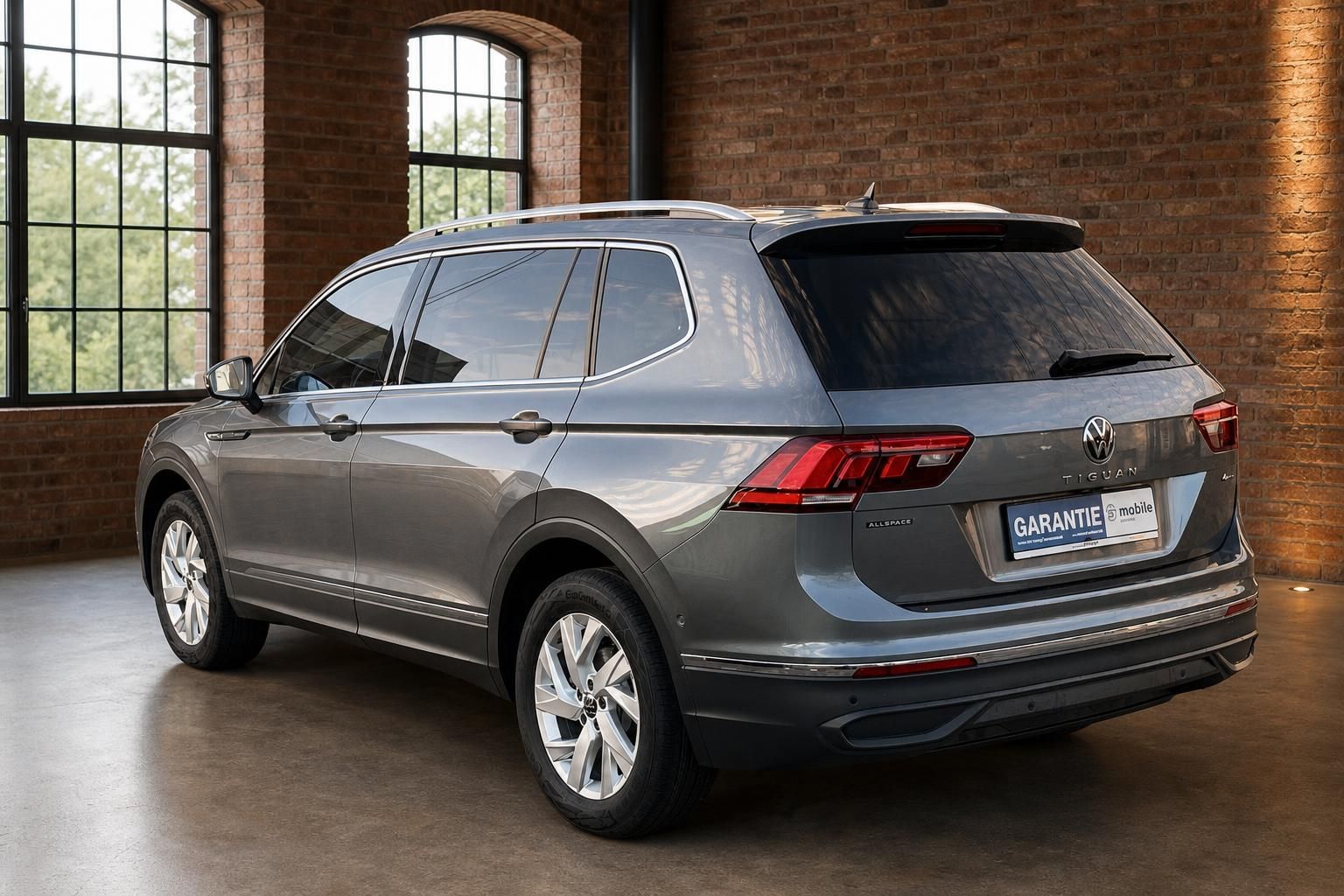 VW Tiguan Allspace grau, Heckansicht mit Dachreling im Showroom