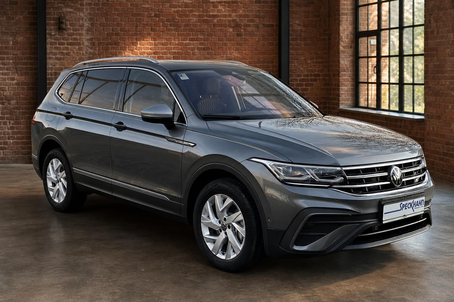 VW Tiguan grau, Front-Seitenansicht mit Chromgrill und Felgen