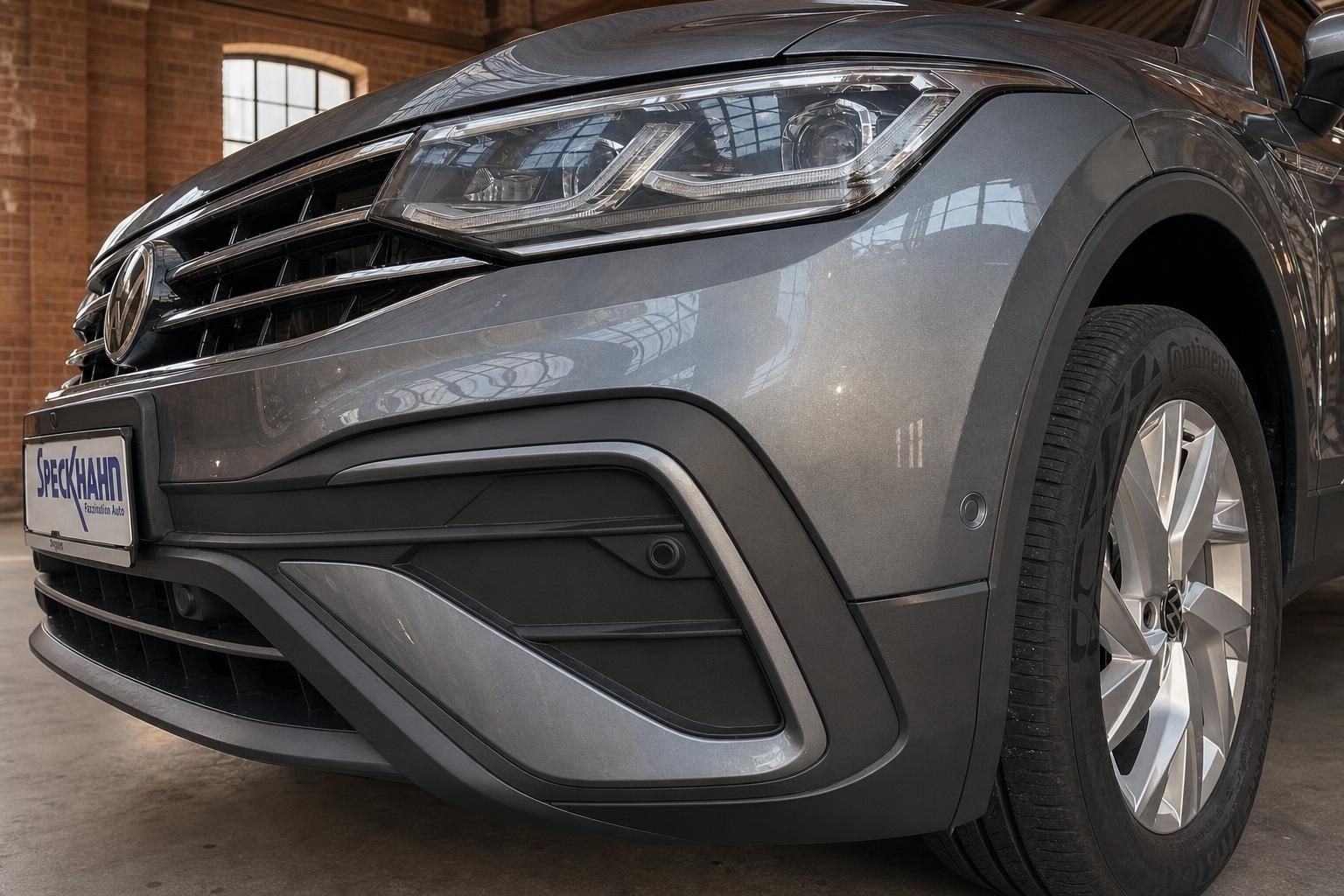 VW Tiguan Frontstoßstange und Scheinwerfer im Detail, grau metallic