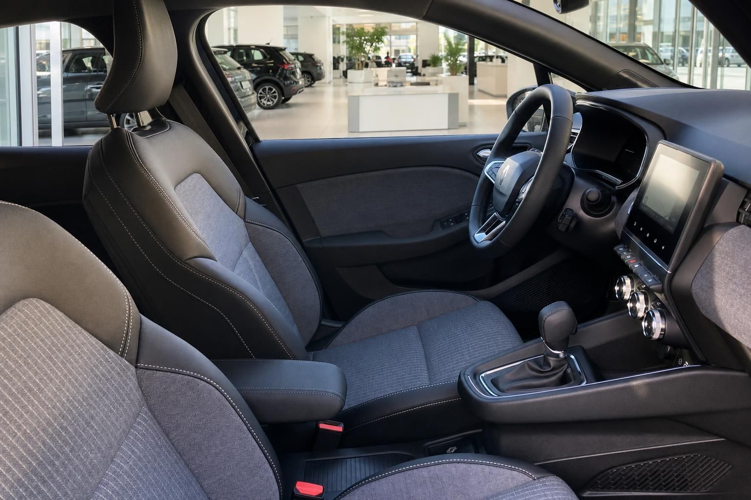 Renault Innenraum mit Ledersitzen, Schaltgetriebe, Lenkrad und Infotainmentsystem im Autohaus