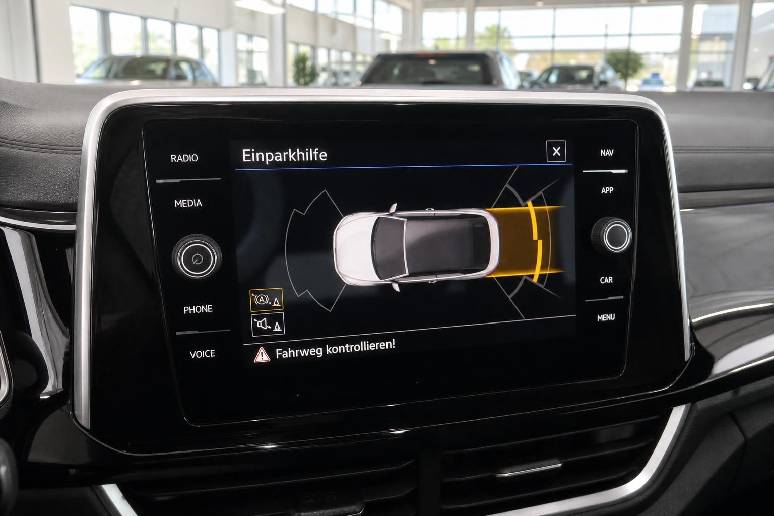 VW Infotainment-Display mit aktivierter Einparkhilfe im Fahrzeuginnenraum
