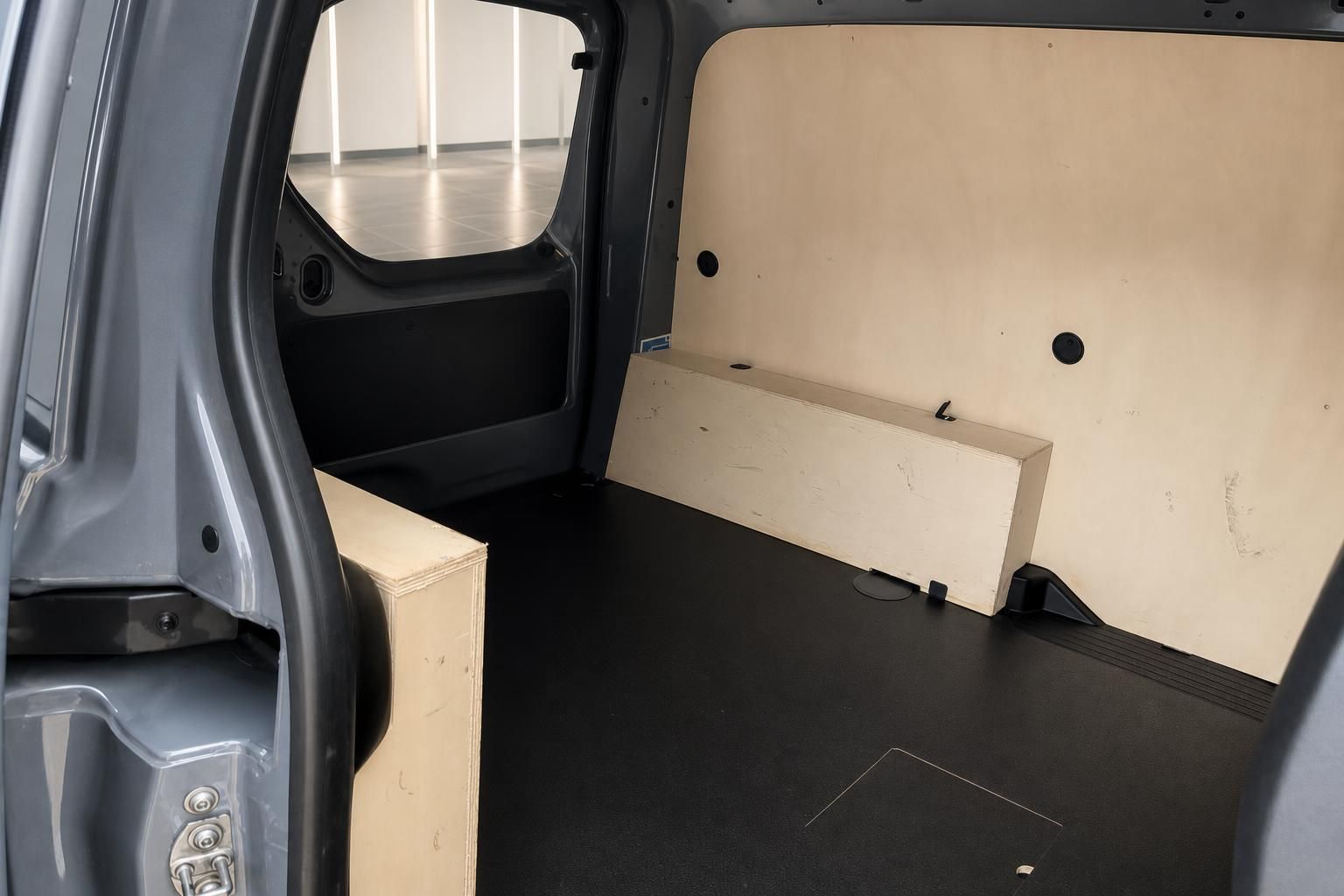 Laderaum eines Transporters mit Holzverkleidung und offenen Türen - geräumiger Nutzfahrzeug-Innenraum