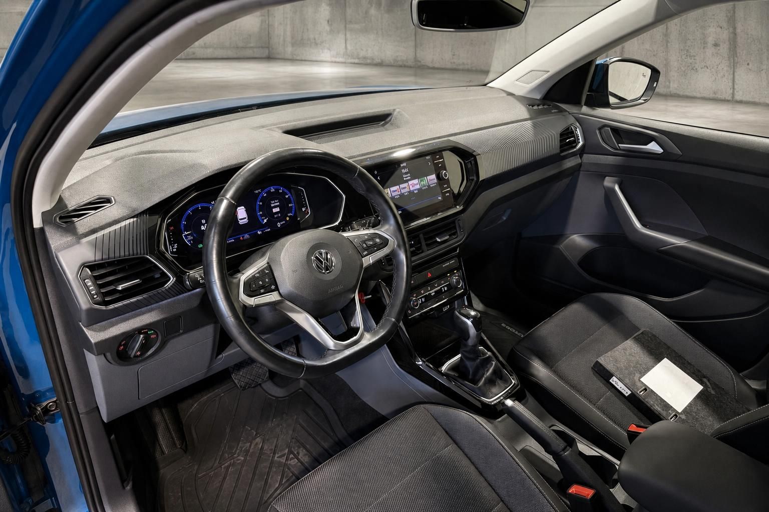 Innenraum eines blauen VW mit Blick auf Lenkrad und Armaturenbrett