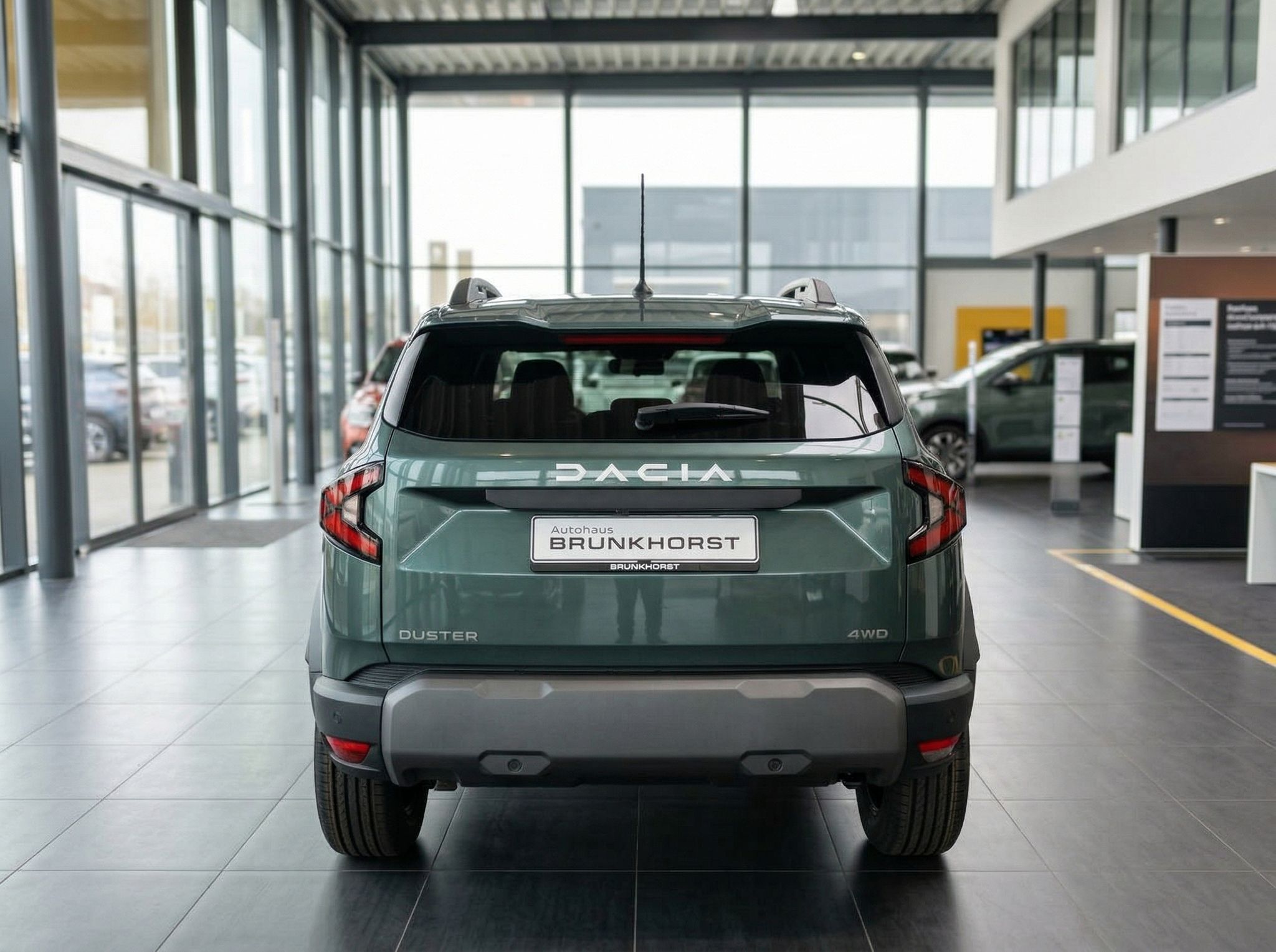 Dacia Duster SUV grün metallic - Heckansicht mit Autohaus Brunkhorst Kennzeichenhalter