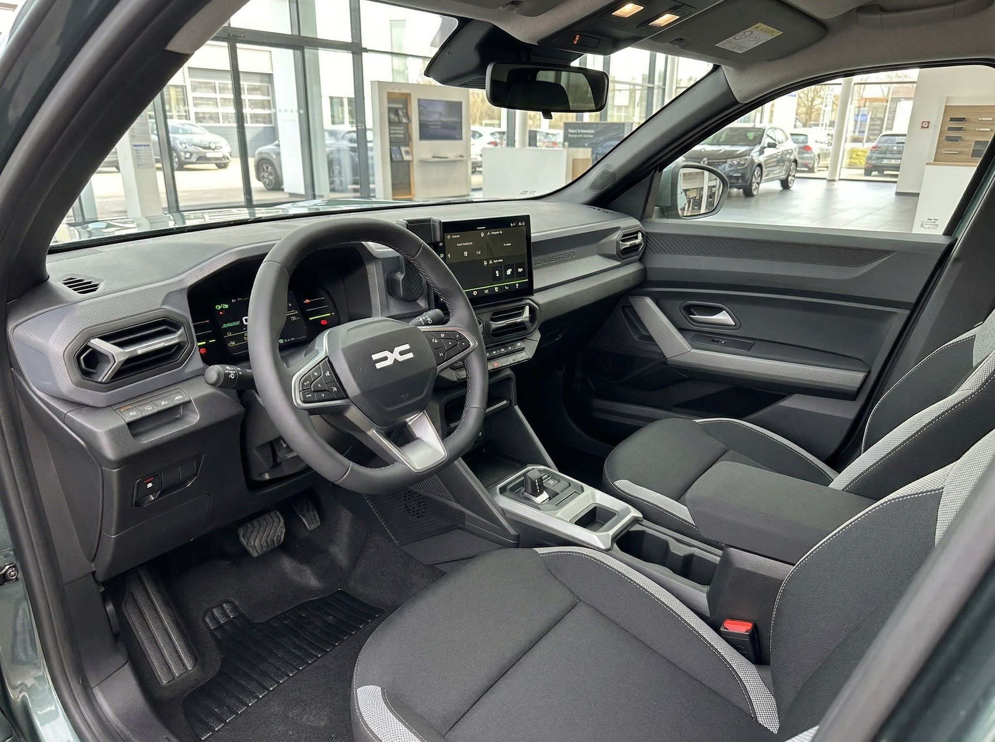 Dacia Fahrzeug Innenraum mit grau-schwarzer Ausstattung und Touchscreen-Display