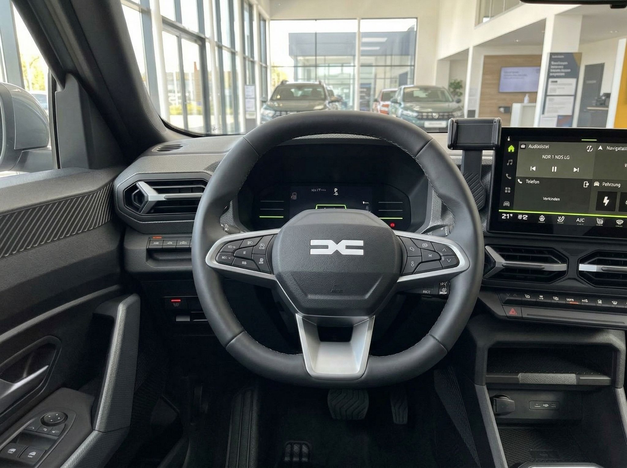 Detailansicht des Armaturenbretts mit Touchscreen und Lenkrad eines modernen Fahrzeugs