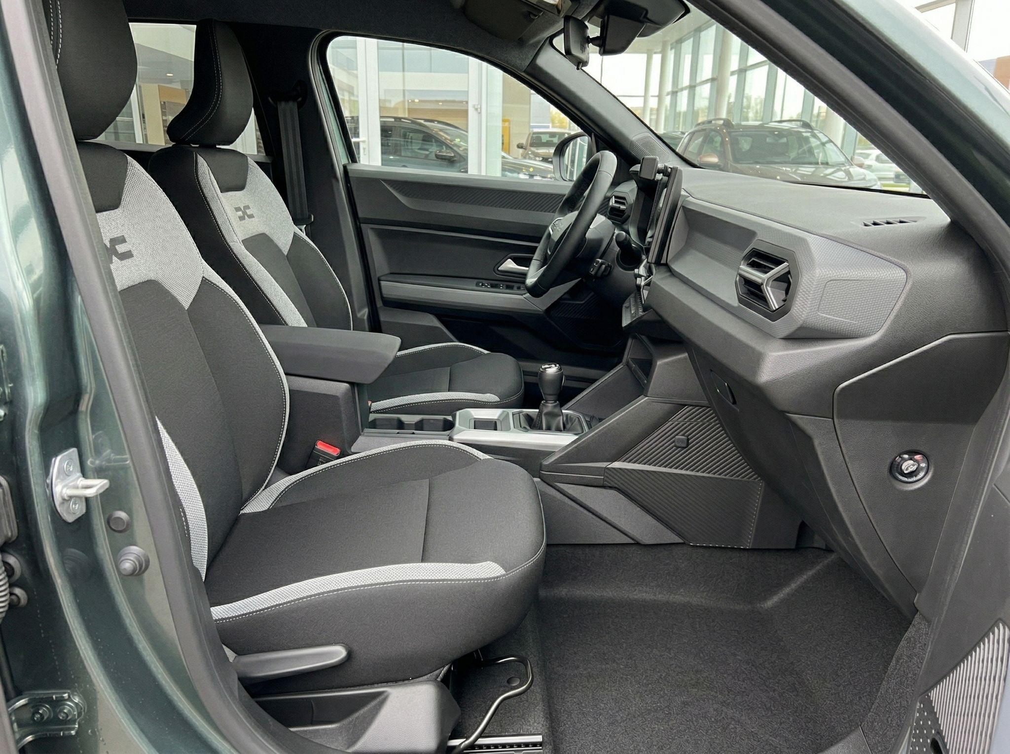 Fahrzeuginnenraum mit grauen Sportsitzen und manueller Schaltung