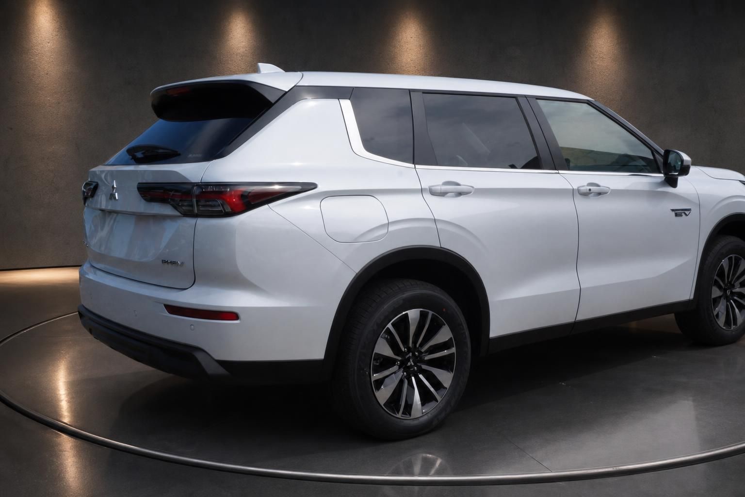 Mitsubishi Outlander PHEV weiss Heckansicht schraeg im Showroom