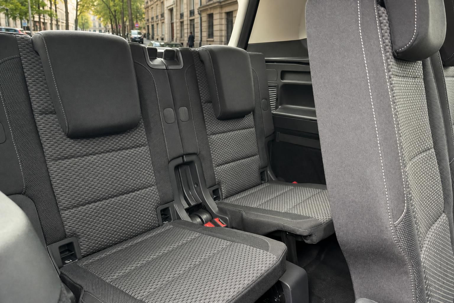 Fahrzeug Innenraum - zweite Sitzreihe mit grauen Stoffsitzen und Sicherheitsgurten