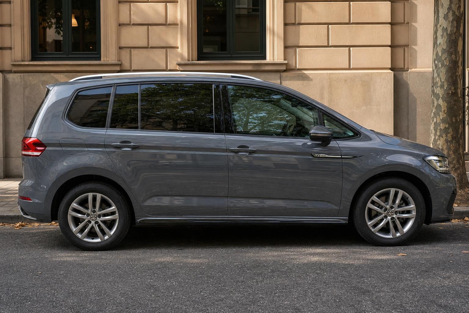 Grauer Volkswagen Van Seitenansicht - modernes Familienauto vor Stadtkulisse