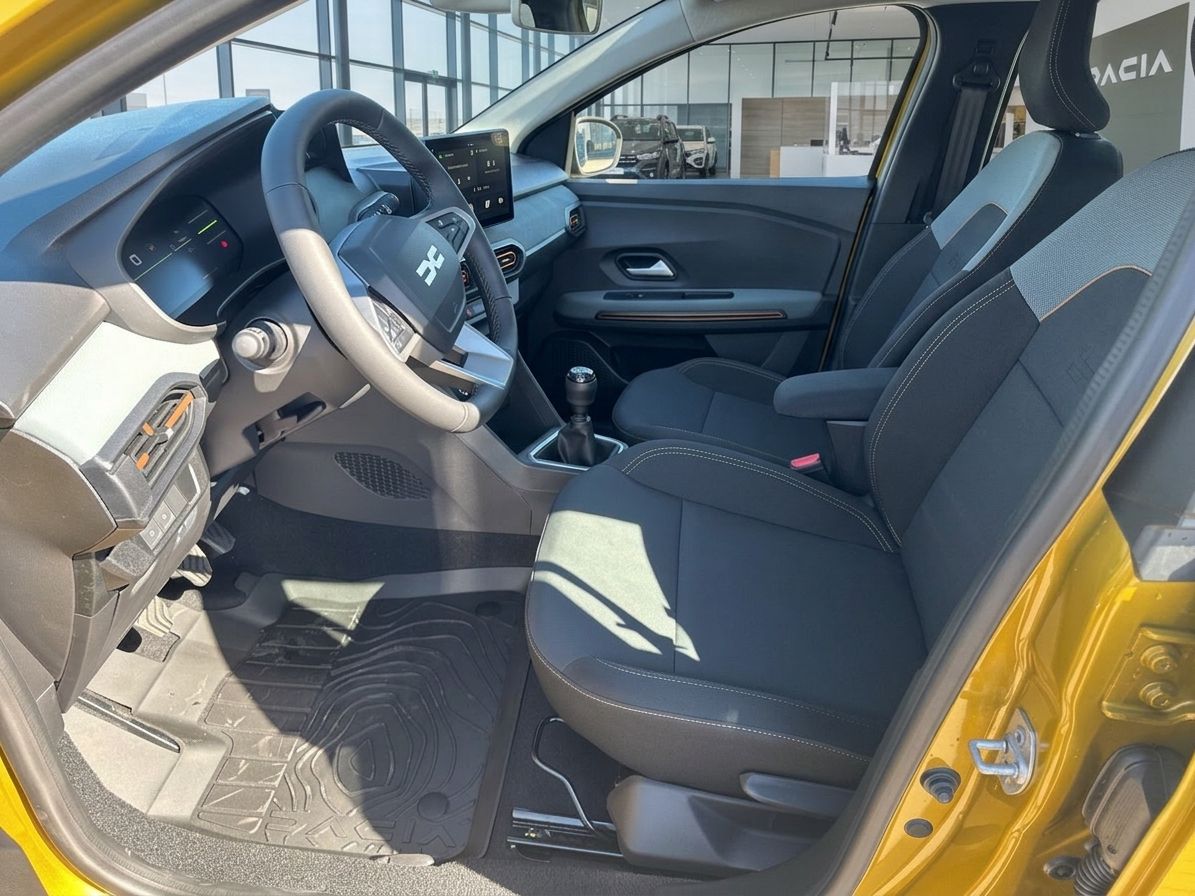 Dacia Innenraum mit Lenkrad, Armaturenbrett und schwarzen Sitzen - Fahrersicht