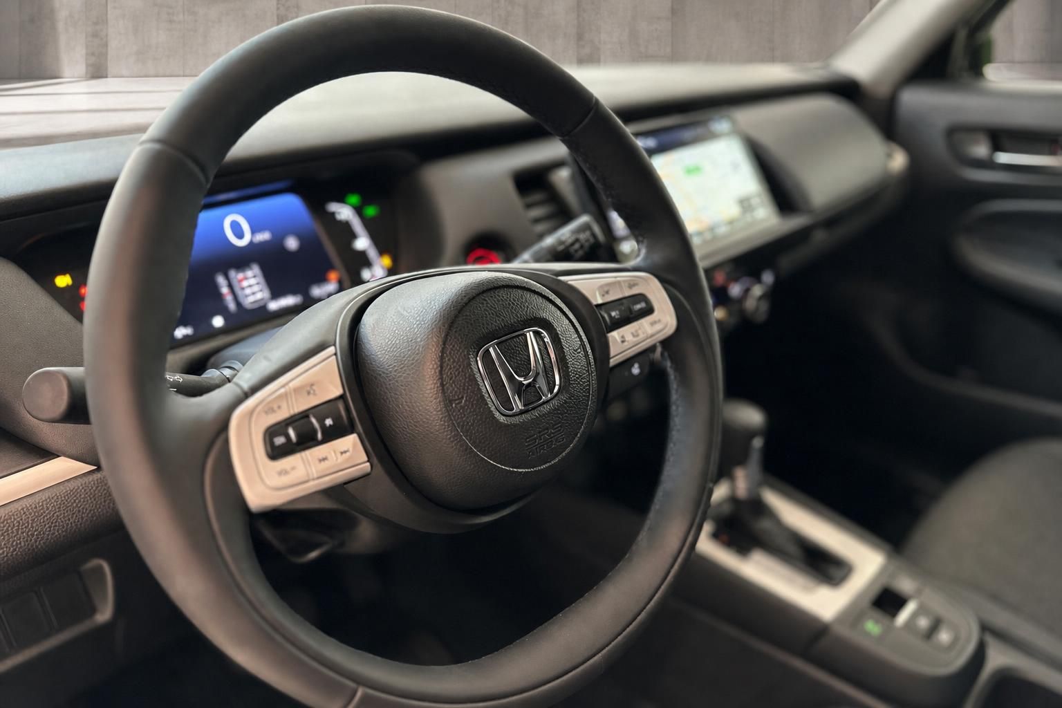 Lederlenkrad mit Multifunktionstasten und Honda Logo im Fahrzeuginnenraum