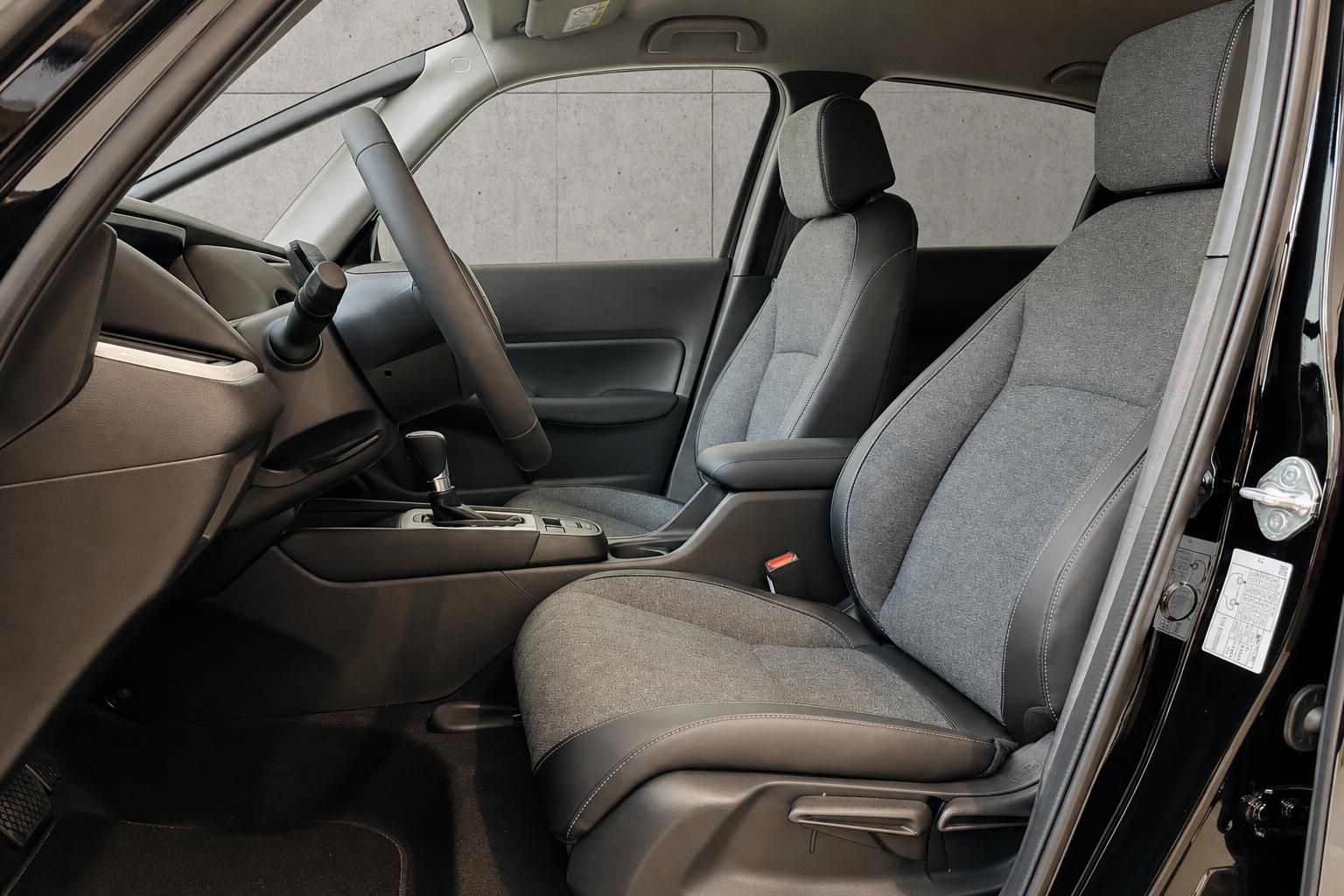 Vordersitze im Fahrzeuginterieur mit Stoff-Leder-Kombination und Automatikgetriebe