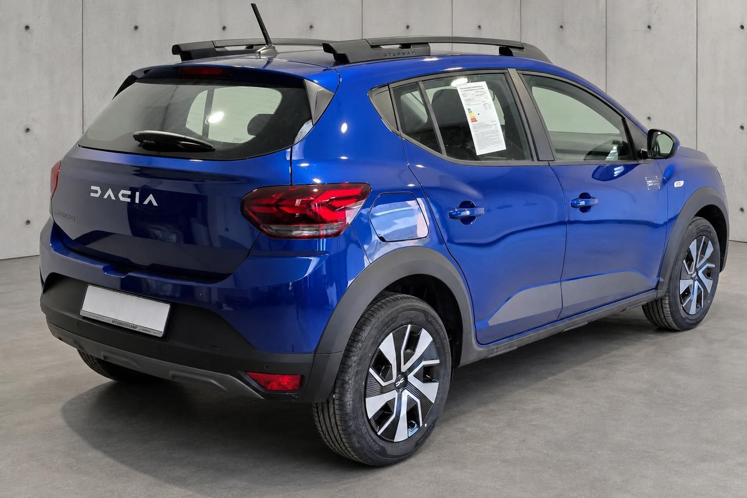 Dacia Sandero Stepway blau Heckansicht schraeg mit Dachreling