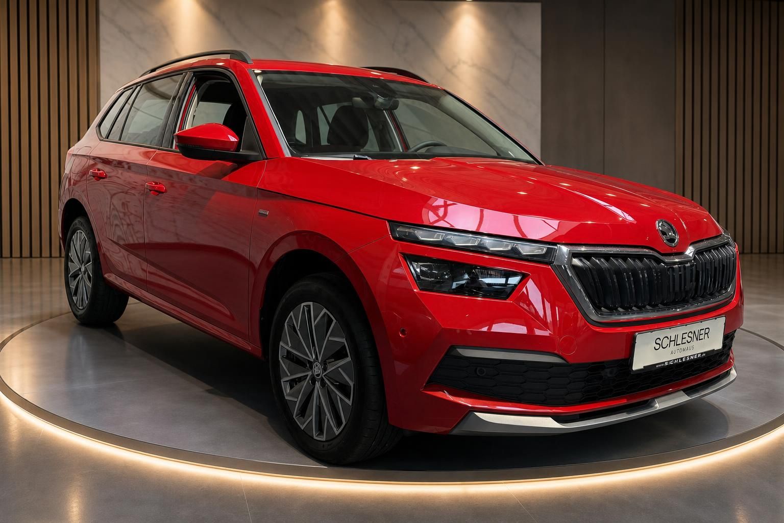 Roter Skoda Kamiq Seitenansicht schraeg auf Drehteller praesentiert