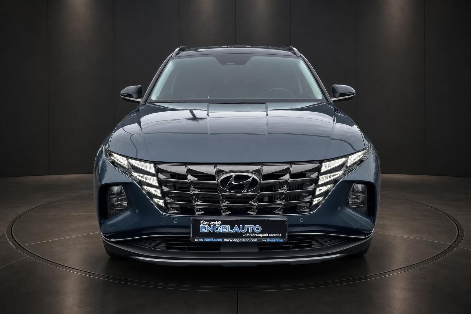 Hyundai Tucson blau Frontansicht im Studio, Kühlergrill und LED-Scheinwerfer