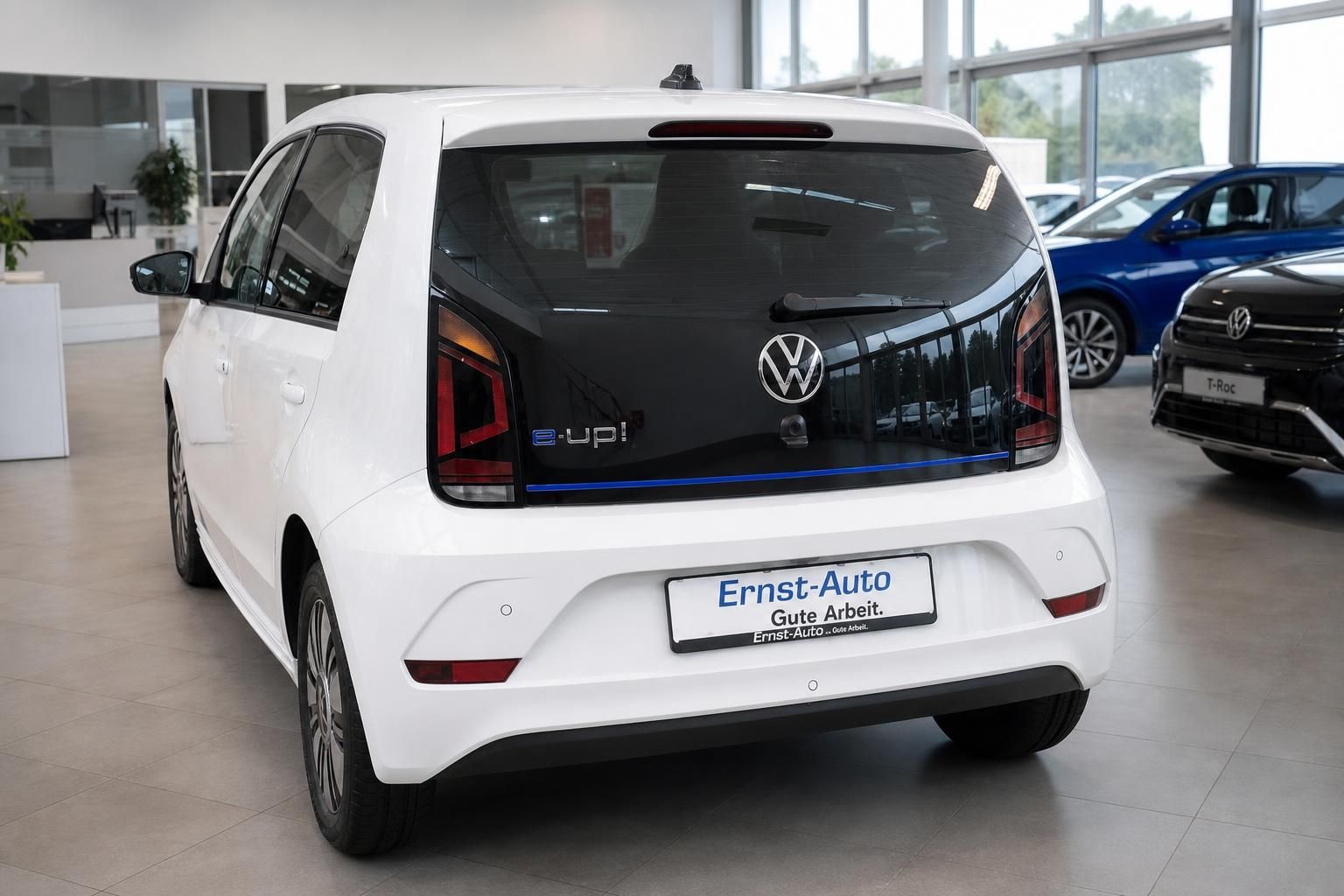VW e-up! weiss Heckansicht im Autohaus mit Ernst-Auto Kennzeichenhalter