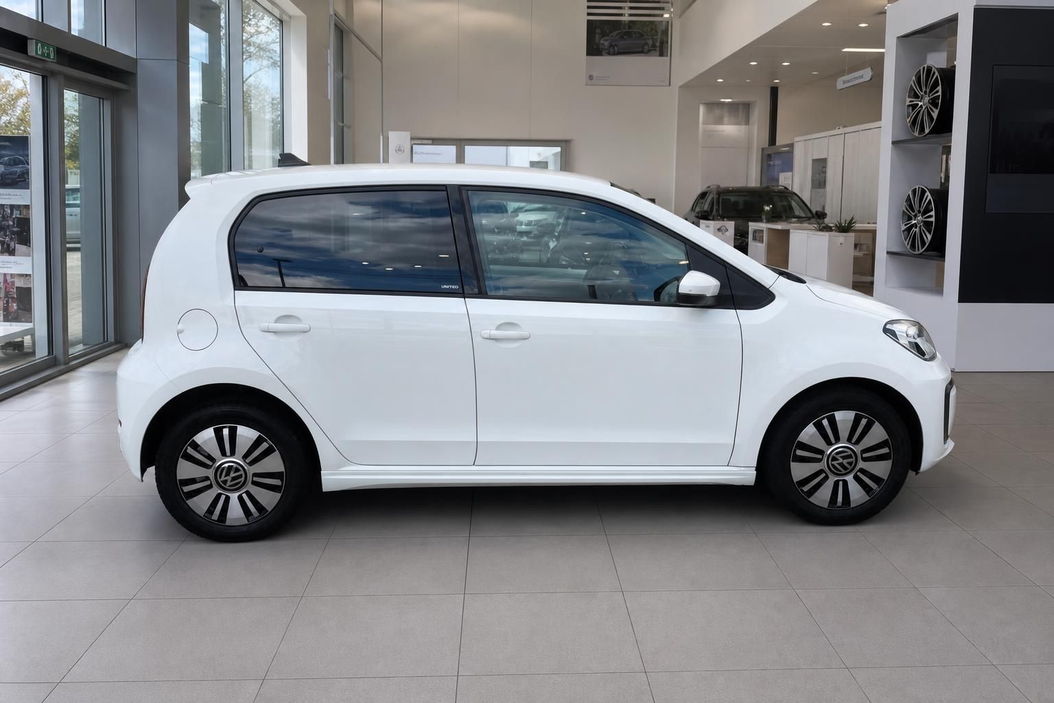 VW e-up! United weiss Seitenansicht rechts im Autohaus Showroom