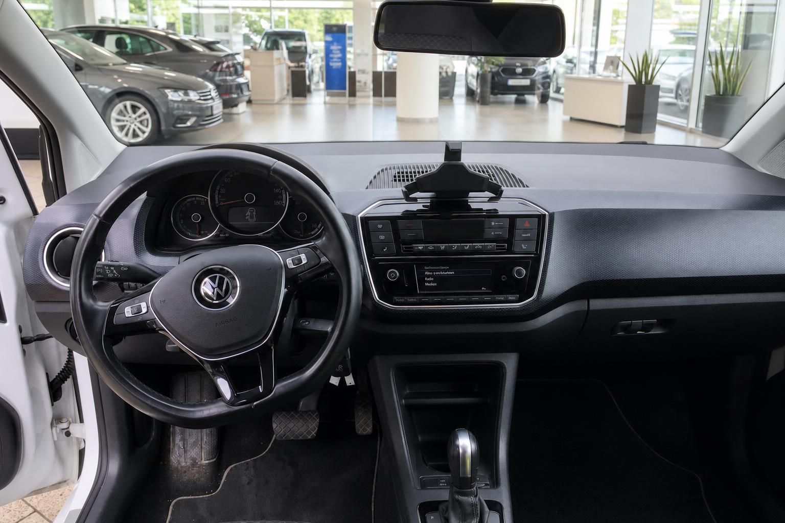 VW up! Innenraum – Cockpit mit Lenkrad, Infotainment und Automatikgetriebe im VW-Autohaus