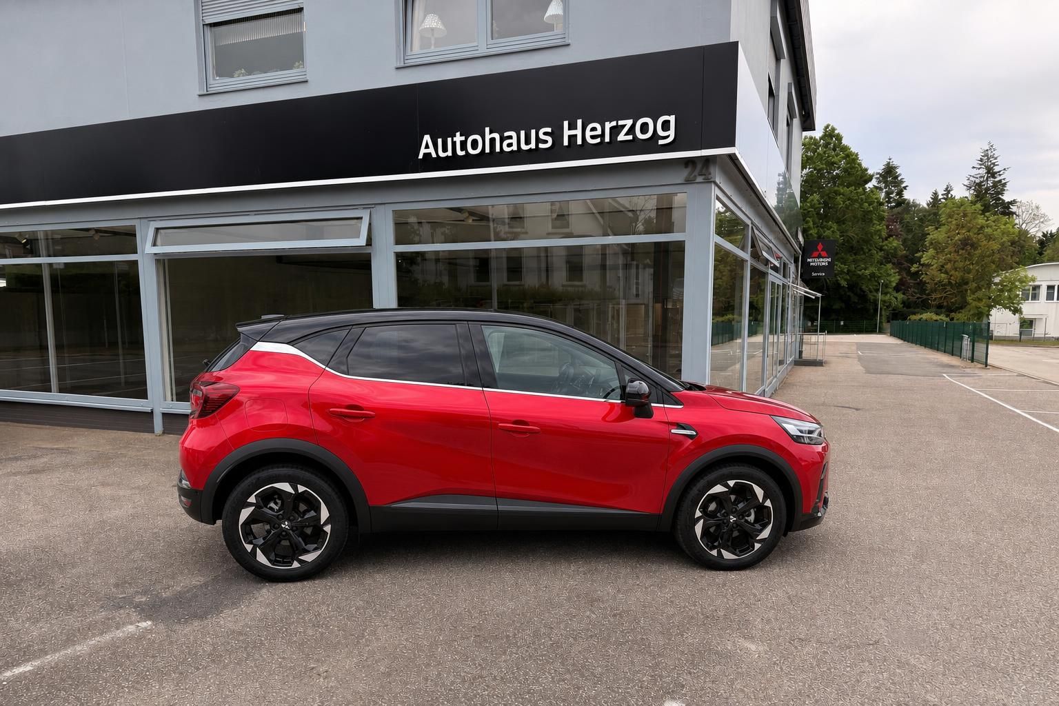 Roter Mitsubishi ASX SUV seitlich vor Autohaus Herzog geparkt
