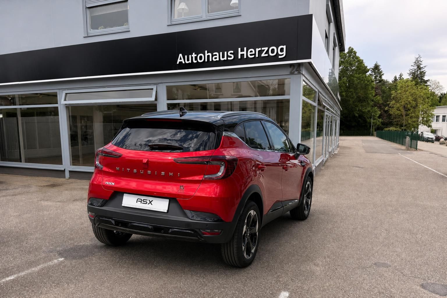 Roter Mitsubishi ASX Heckansicht vor Autohausgebaeude
