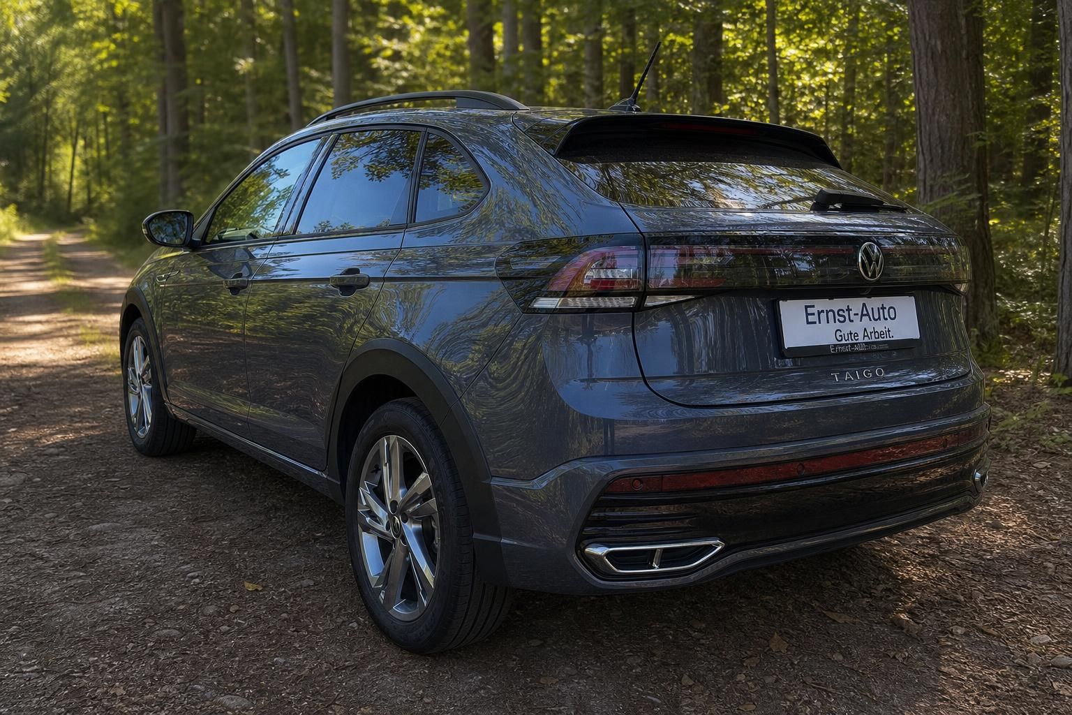 VW Taigo SUV seitliche Rückansicht grau mit Alufelgen auf Waldweg - Gebrauchtwagen Ernst-Auto