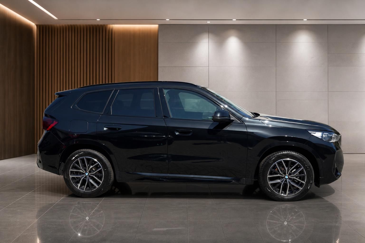 BMW X1 schwarz Seitenansicht im Autohaus Showroom