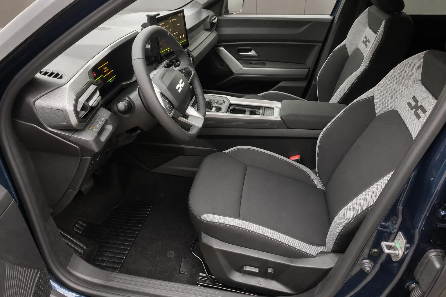 Fahrzeug Innenraum mit grau-weißen Sportsitzen, Lenkrad und modernem Infotainment-Display