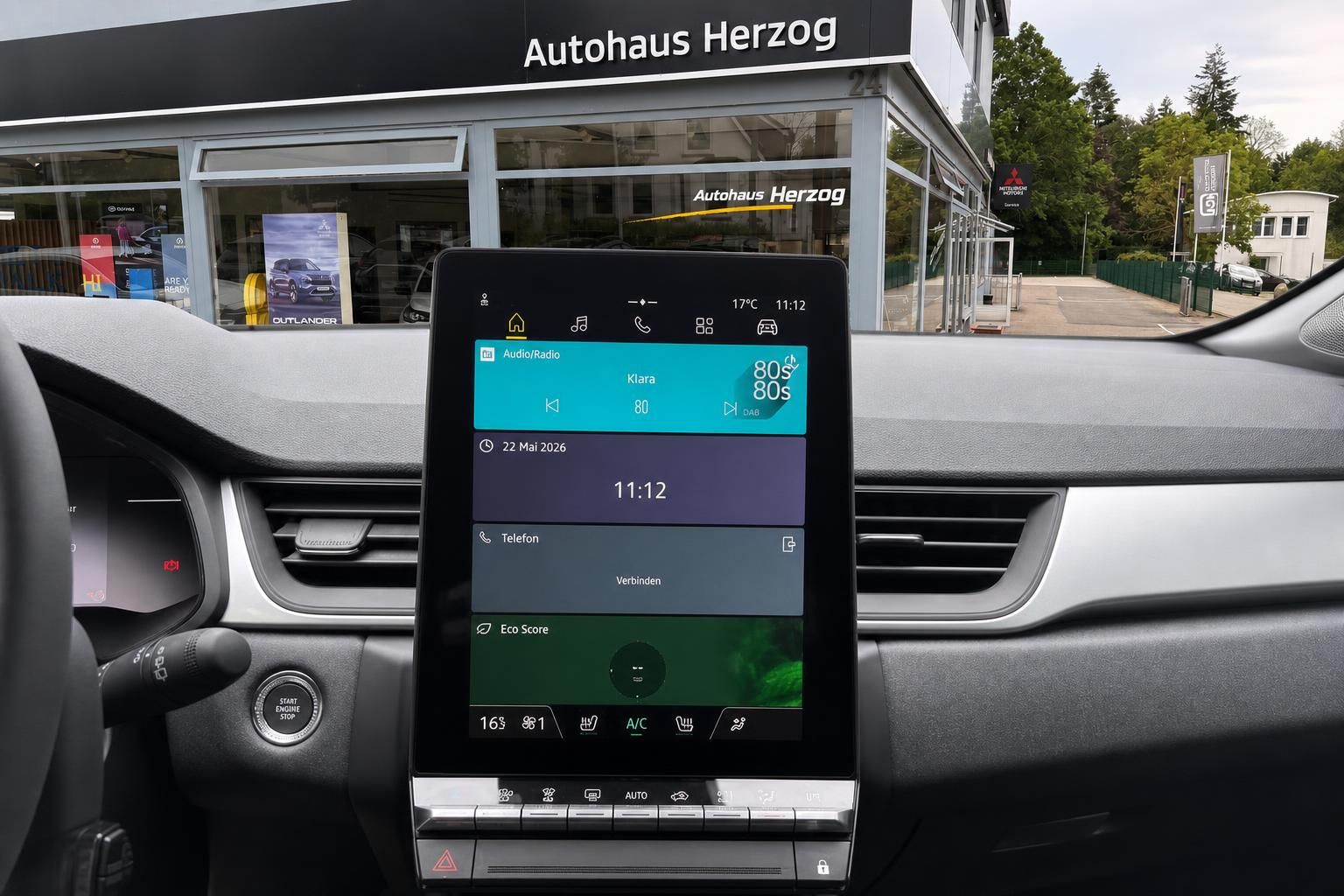 Mitsubishi Cockpit mit Infotainment-Bildschirm vor Autohaus Herzog