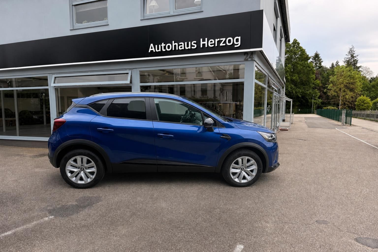 Blauer Mitsubishi SUV Seitenansicht vor dem Autohaus Herzog