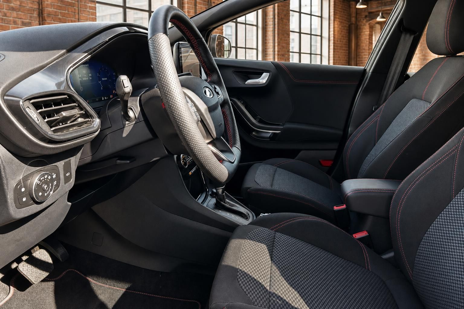 Ford Innenraum Vordersitze mit Sportlenkrad und roten Ziernaehten