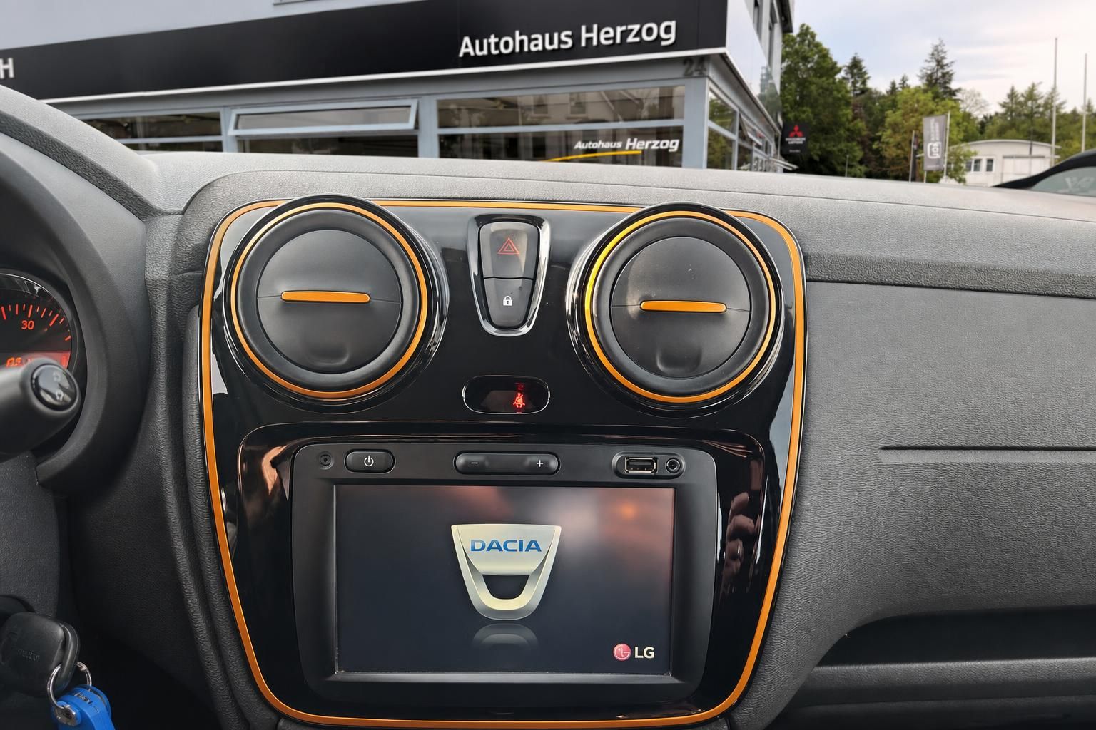 Dacia Stepway Innenraum - Multimedia-Display und Lüftungsdüsen in orange-schwarzem Design