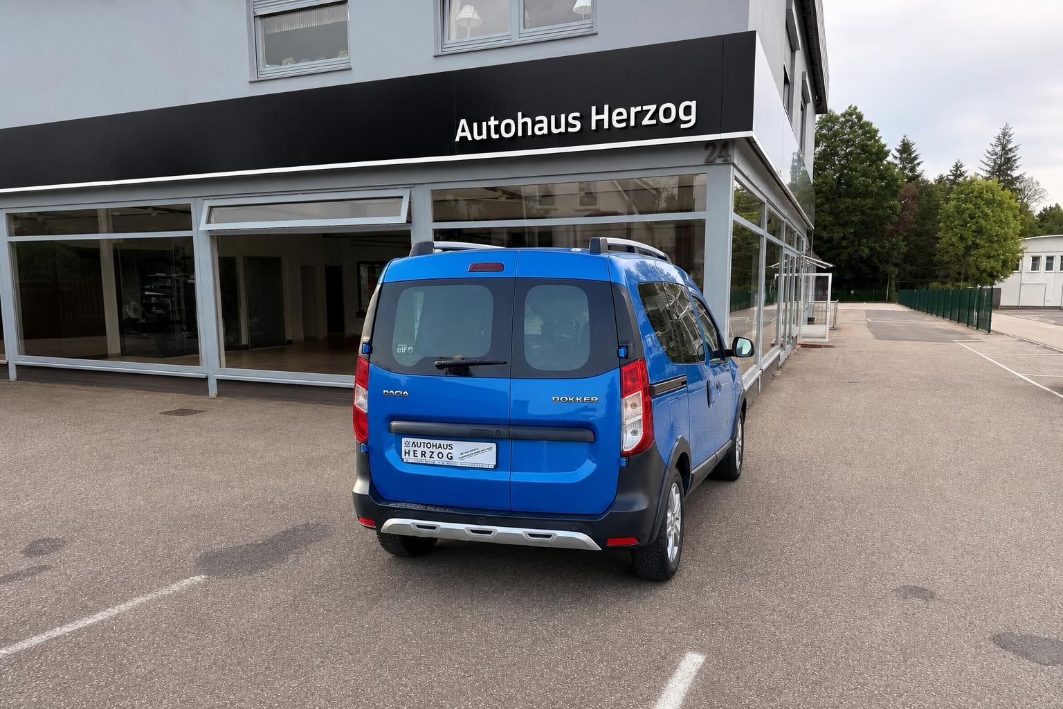 Blauer Dacia Dokker Stepway Van - Heckansicht vor Autohaus Herzog