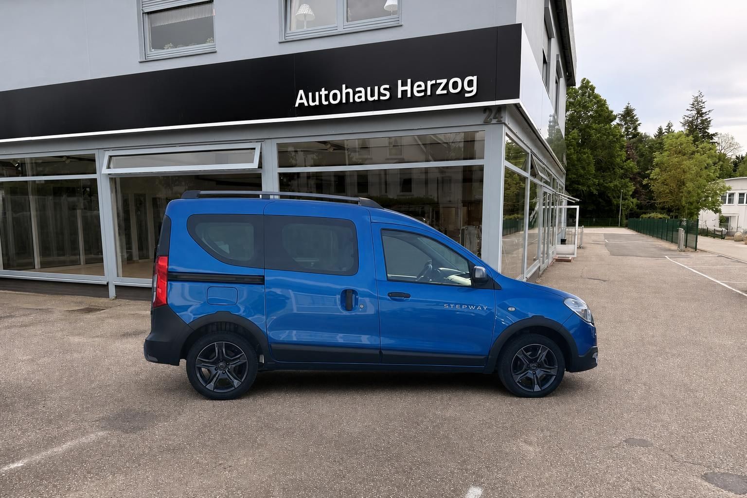 Blauer Dacia Stepway Seitenansicht vor Autohaus Herzog - Gebrauchtwagen Kleinwagen