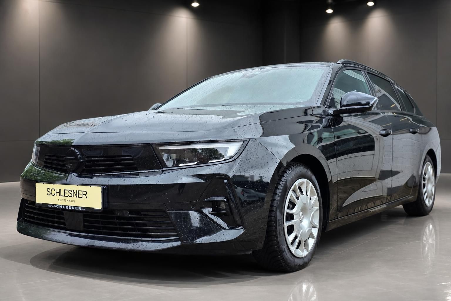 Opel Astra Kombi schwarz, Frontansicht schraeg links im Showroom
