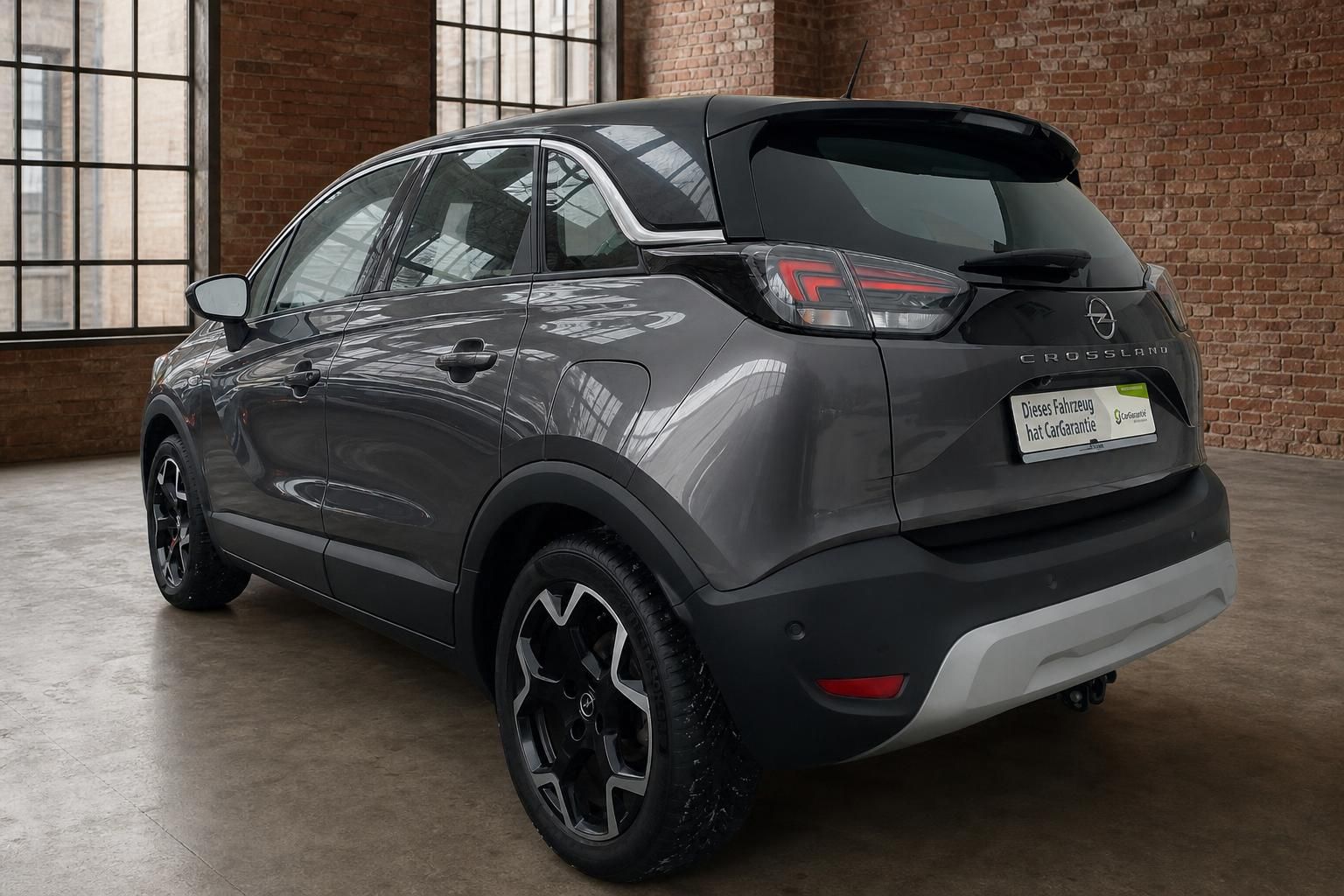 Opel Crossland grau Heckansicht schräg links mit LED-Rückleuchten und Anhängerkupplung