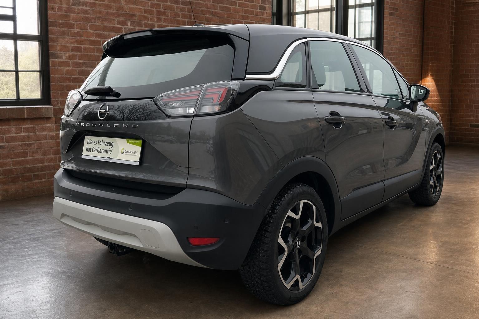Opel Crossland grau Heckansicht schräg rechts mit LED-Rückleuchten und Anhängerkupplung