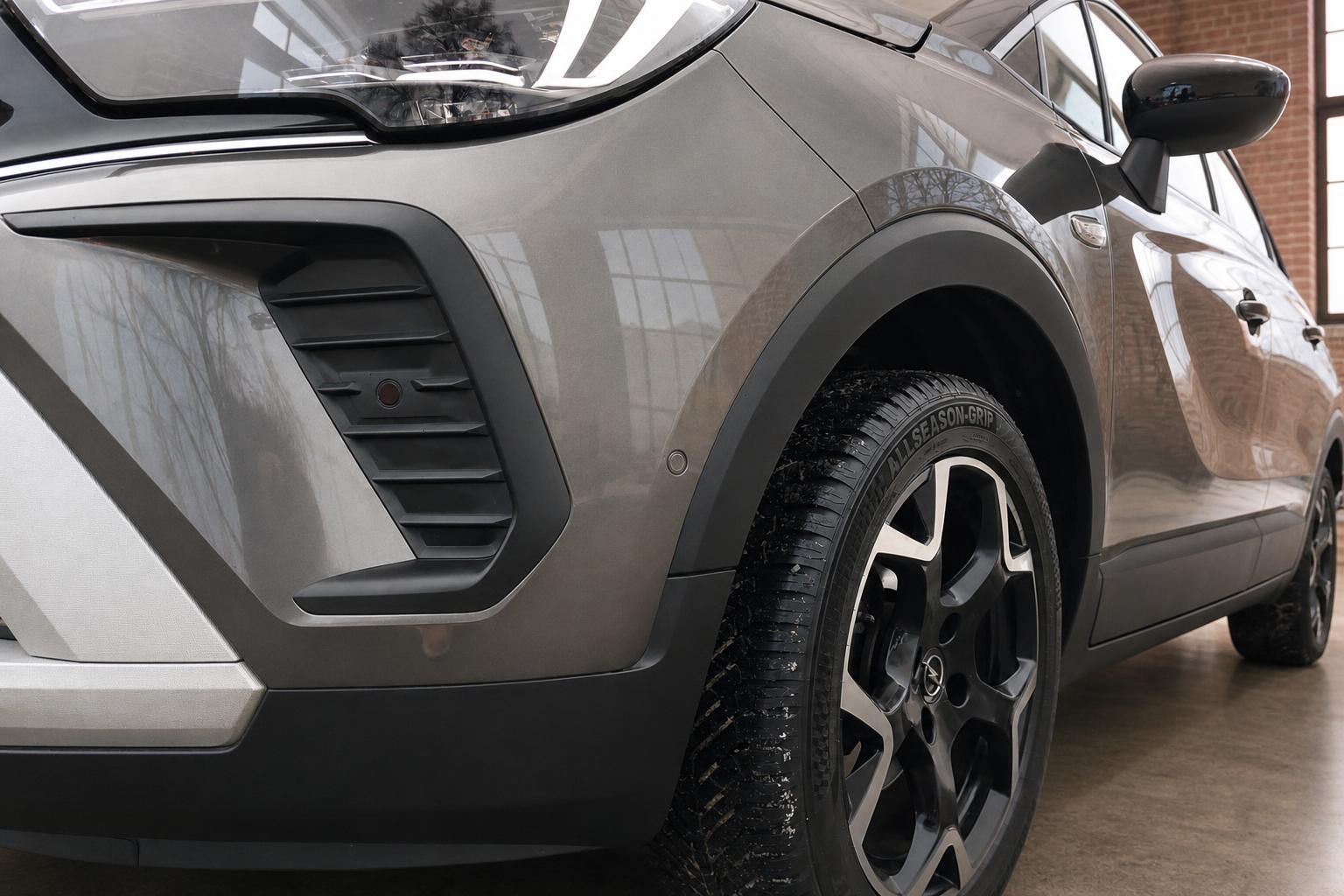 Opel Crossland Detailaufnahme Frontschürze und Rad mit Allseason-Grip Bereifung grau