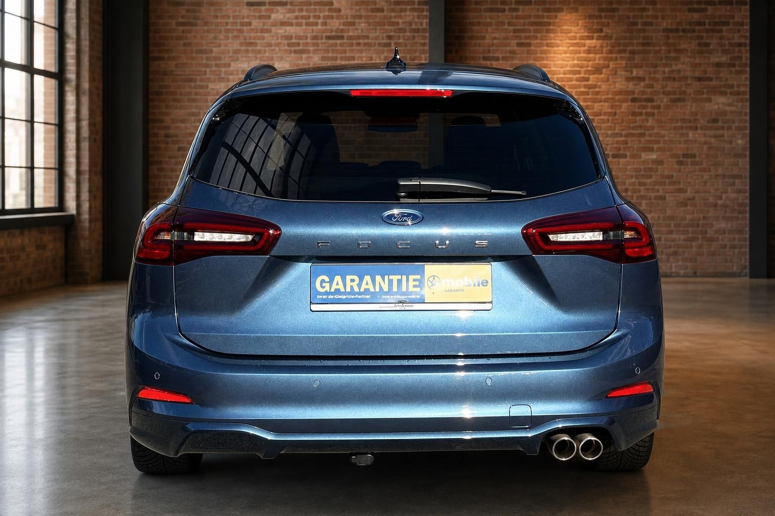 Ford Focus Turnier blau metallic Heckansicht gerade mit Garantiemobil-Kennzeichenhalter