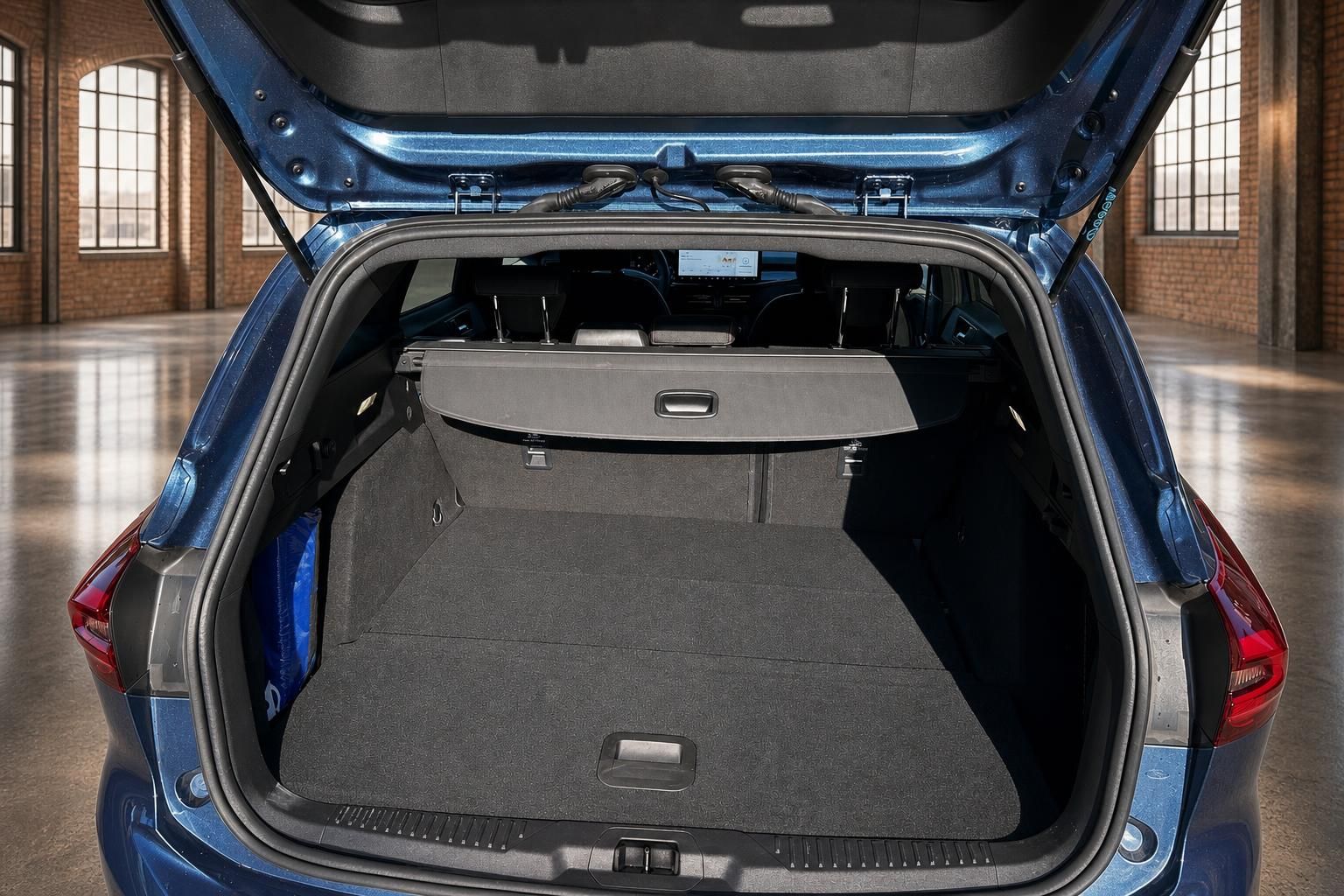 Ford Focus Kombi blau geöffneter Kofferraum mit Laderaumabdeckung und großem Ladevolumen