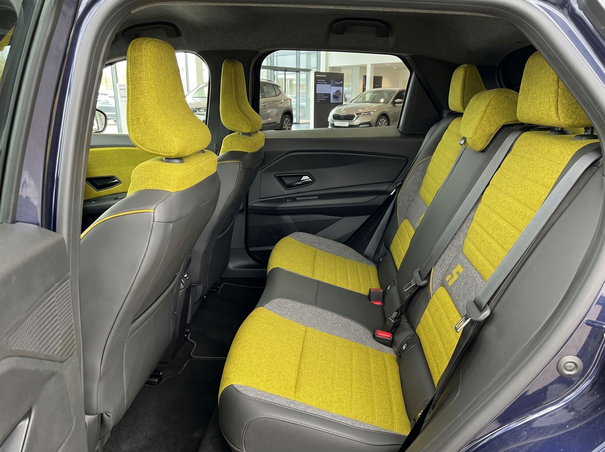 Renault Rückbank mit gelben Sitzen und Blick durch die Heckscheibe ins Autohaus