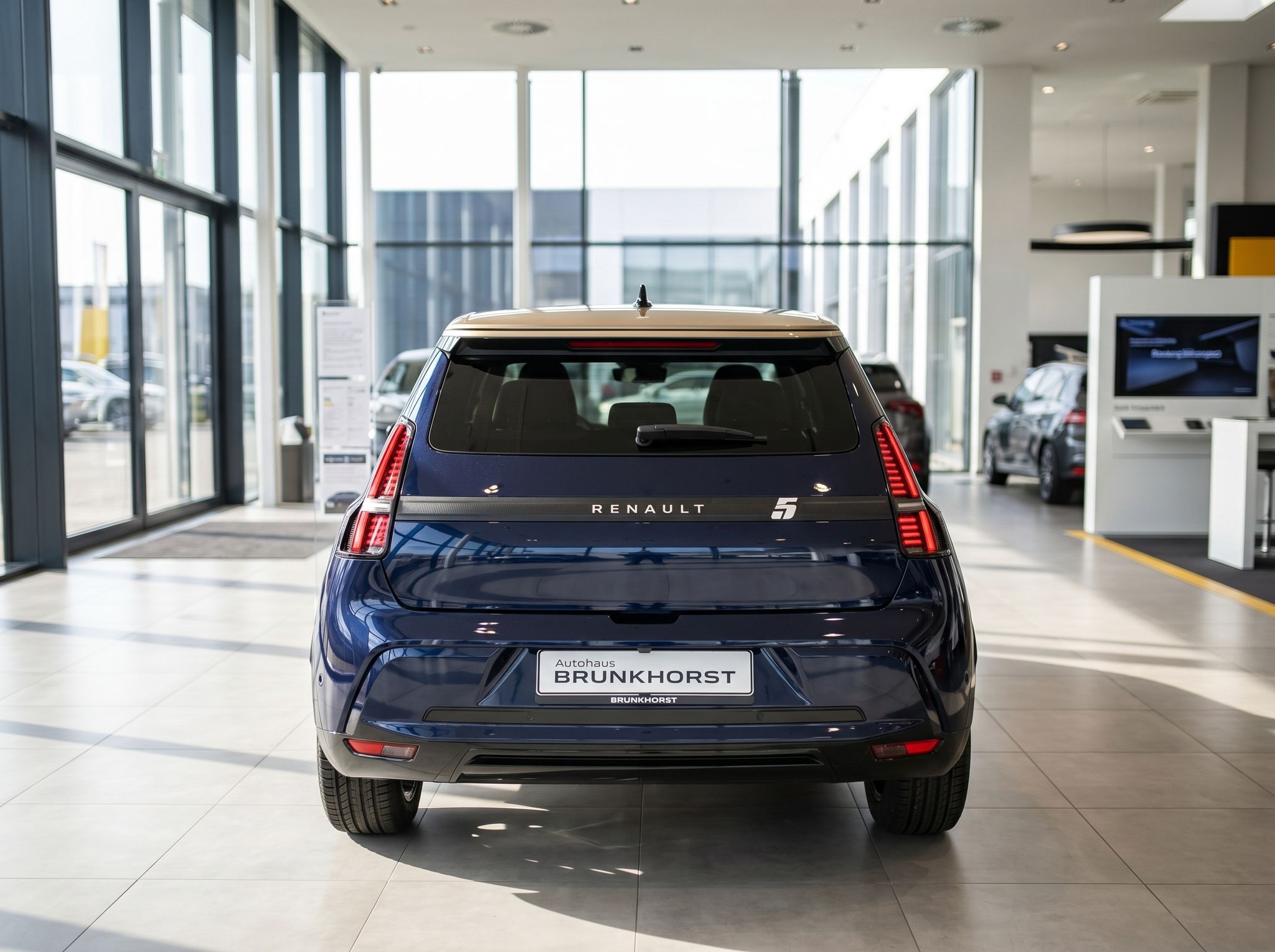 Renault 5 Elektroauto Heckansicht dunkelblau im Autohaus mit roten Rückleuchten